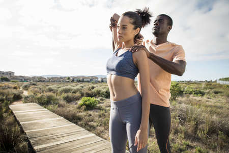 Man helping friend stretching armの写真素材