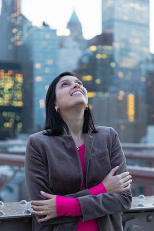 Female tourist looking up from Brooklyn Bridge, New York, USAの写真素材