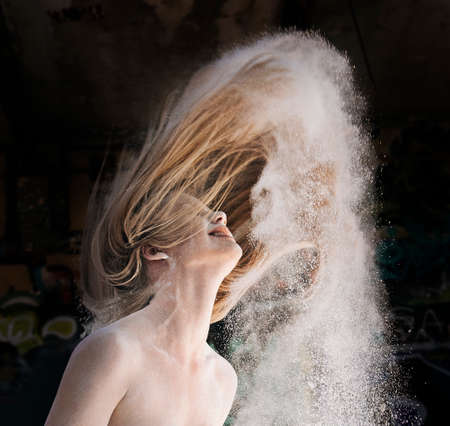 Powder covered woman throwing hair backの写真素材