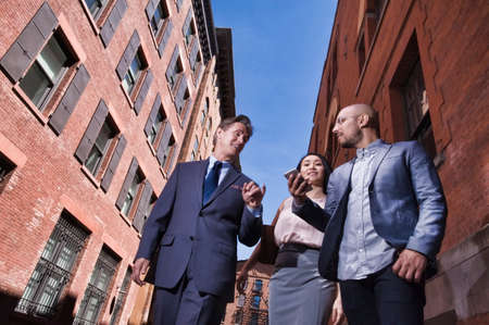Businessmen and women walking outdoors, low angle viewの写真素材