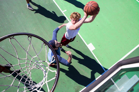 Group of male friends playing basketball on outdoor court, elevated viewの写真素材
