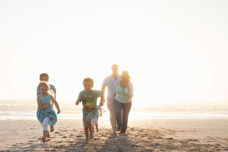 Front view of family running on beachの写真素材
