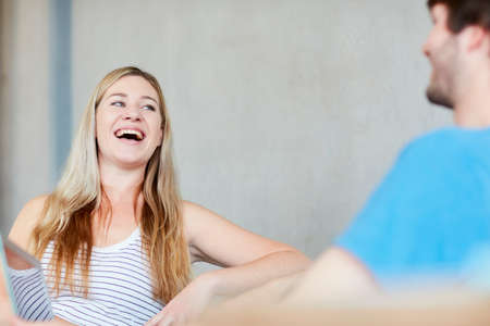 Young male and female students chatting and laughing at higher education college