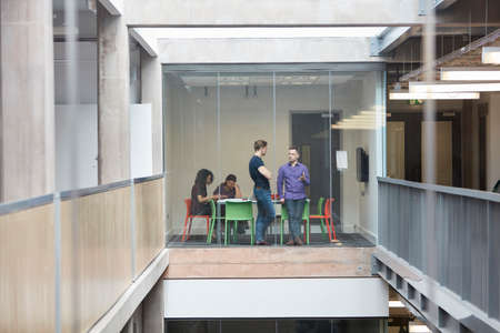 Designers having discussion at design studio boardroomの写真素材