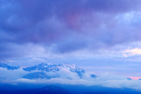 Mist and snow capped mountains at dawn,  Bolshoy Thach (Big Thach) Nature Park, Caucasian Mountains, Republic of Adygea, Russiaの写真素材
