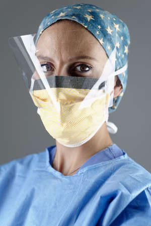 Surgeon wearing surgical eye guard and face mask looking at cameraの写真素材