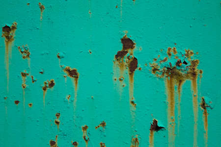 Peeling turquoise paint and rust on metal surfaceの写真素材