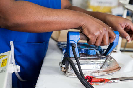 Worker using iron in garment factoryの写真素材
