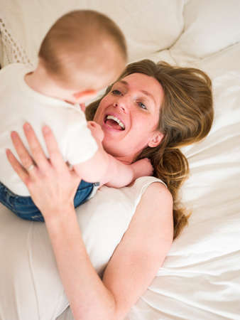 High angle view of baby girl sitting on motherの写真素材