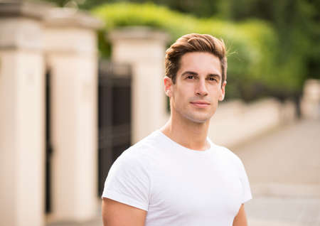 Portrait of young man standing on city street, London, UKの写真素材