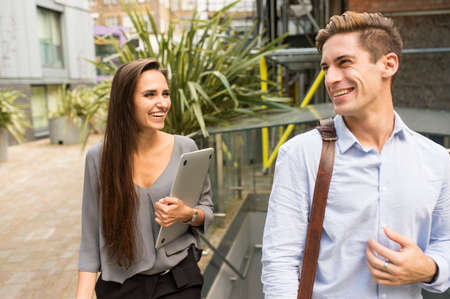 Young businesswoman and man walking and talking, London, UK