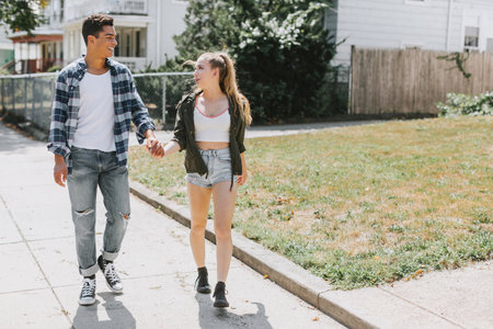Couple walking in street holding handsの写真素材