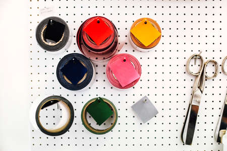 Rolls of coloured tape and scissors on wall in print workshopの写真素材