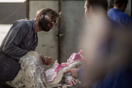 Sculptors in artist studio creating plaster cast sculptureの写真素材