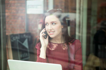 Businesswoman working with laptop in cafeの写真素材