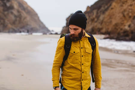 Hiker walking on beach, Big Sur, California, USA