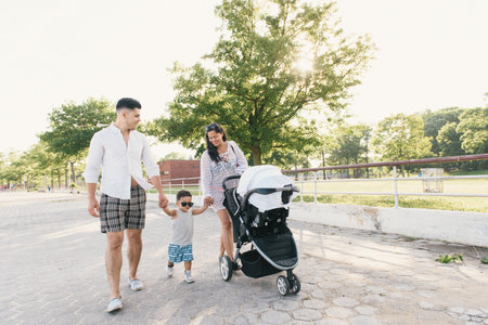 Parents walking with toddler son and pushchair at Pelham Bay Park, Bronx, New York, USAの写真素材