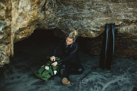 Diver with speargun resting on beach, Big Sur, California, USAの写真素材