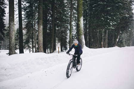 Woman mountain biking in snow, Sequoia National Park, California, USAの写真素材