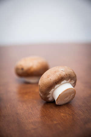 Two mushrooms on wooden table