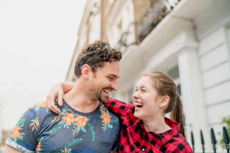 Young happy couple strolling along street, Kings Road, London, UKの写真素材