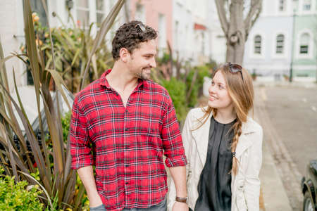 Young woman and boyfriend strolling on street, Kings Road, London, UK