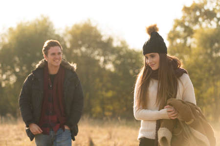 Young couple walking through field, smilingの写真素材