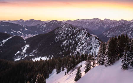 Snow-covered mountain landscape at sunrise, Teufelstattkopf mountain, Oberammergau, Bavaria, Germanyの写真素材