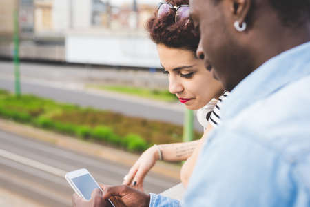 Couple looking at smartphone, Milan, Italyの写真素材