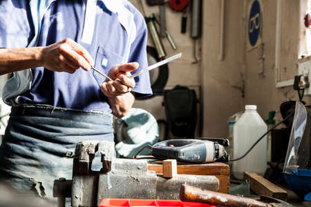 Mid section of young man using screwdriver in repair workshop