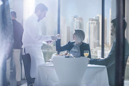 Businessman and woman having breakfast in hotel restaurant