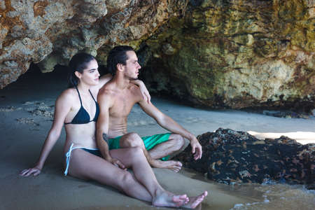 Young couple looking out from beach cave, Taiba, Ceara, Brazilの写真素材