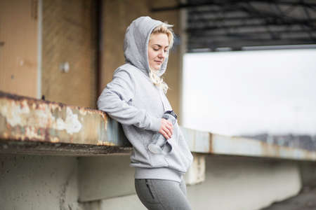 Female runner leaning against warehouse platformの写真素材