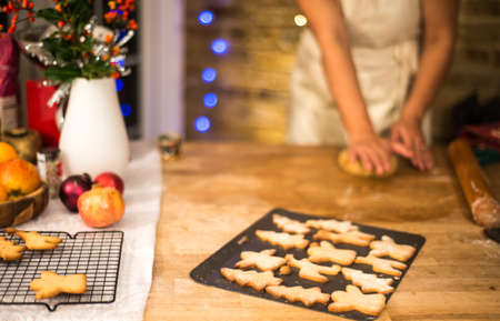 Mid section of woman flattening Christmas cookie pastry at kitchen counterの写真素材