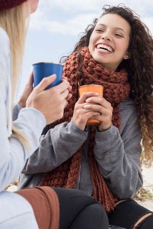 Two young women laughing at beach picnic, Western Cape, South Africaの写真素材