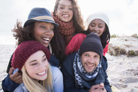 Portrait of young adult friends lying on top of each other on beach, Western Cape, South Africaの写真素材