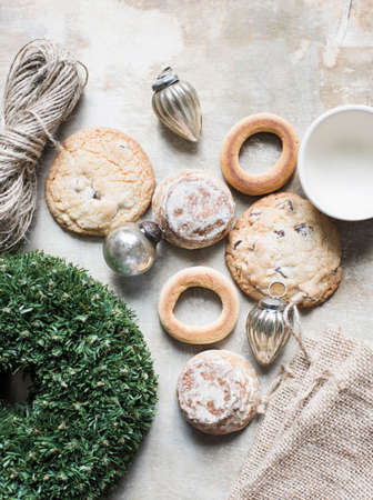 Overhead view of silver Christmas baubles and fresh cookies and bagels