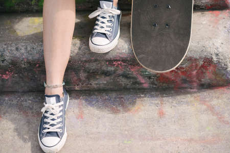 Feet of female skateboarder with skateboard on stepの写真素材