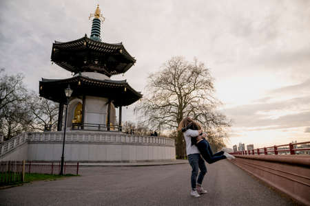 Romantic young man lifting girlfriend in Battersea Park, London, UKの写真素材