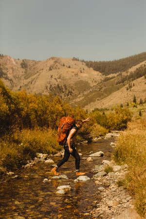 Man, wearing backpack, crossing creek, Mineral King, Sequoia National Park, California, USAの写真素材
