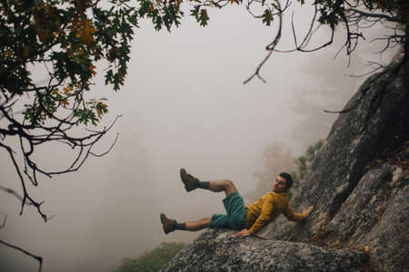 Young man falling on rock, near Shaver Lake, California, USA