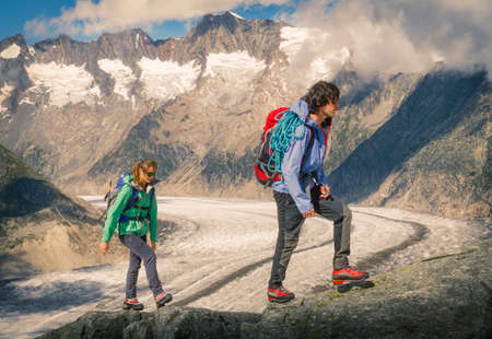 Couple climbing up ridge over Aletsch Glacier, Canton Wallis, Switzerlandの写真素材