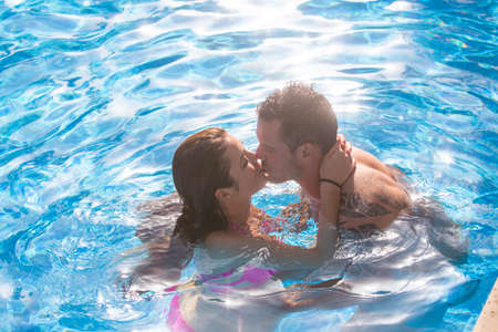 Couple in swimming pool kissingの写真素材