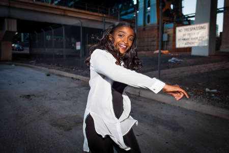 Young woman dancing in street, smiling