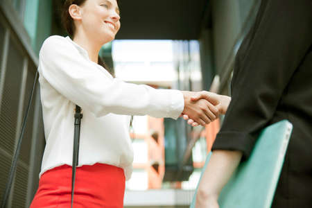 Businesswomen shaking hands at meeting, Londonの写真素材