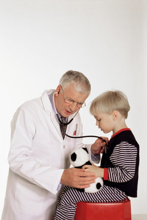 Doctor listening to boy's chestの写真素材