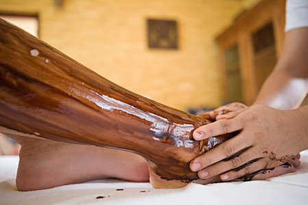 Applying oil to womans legの写真素材