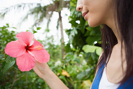 Woman holding pink flowerの写真素材