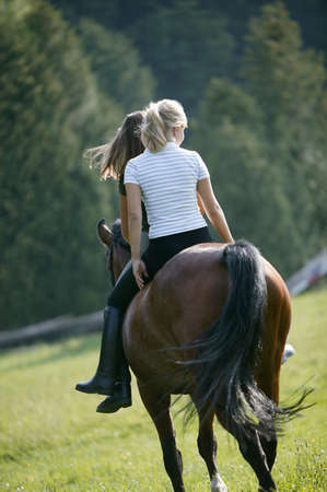 Two young women on a horseの写真素材