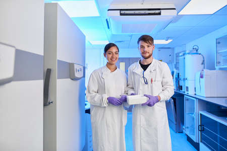 Scientists in laboratory looking at cameraの写真素材